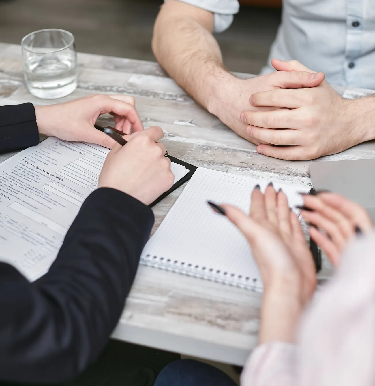 Duas pessoas numa reunião de trabalho, com um caderno de notas aberto sobre a mesa
